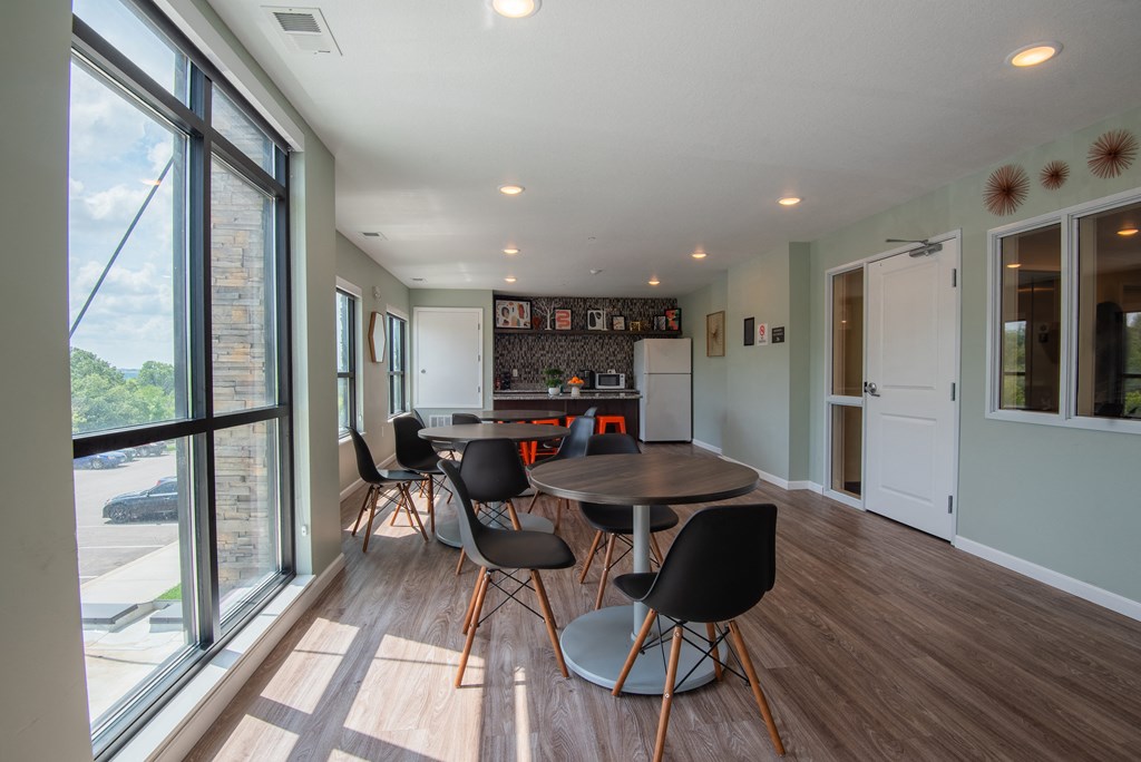 a dining room with a table and chairs and a kitchen with a large window