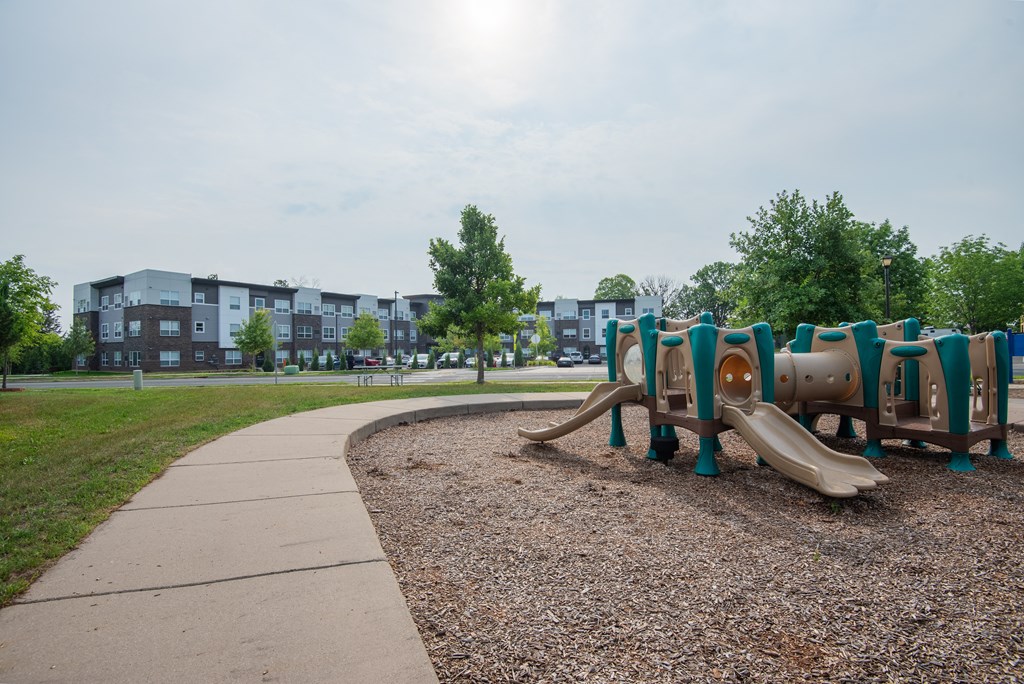 a playground at a park with a sidewalk