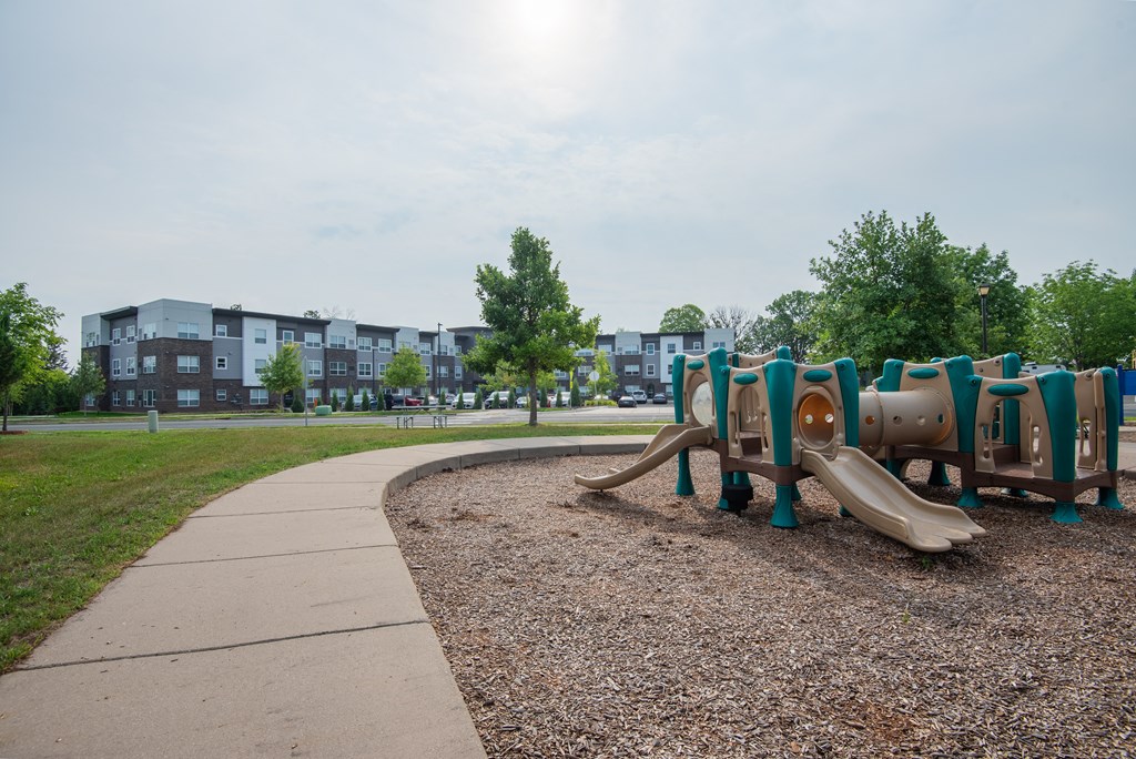 a playground at a park with a sidewalk