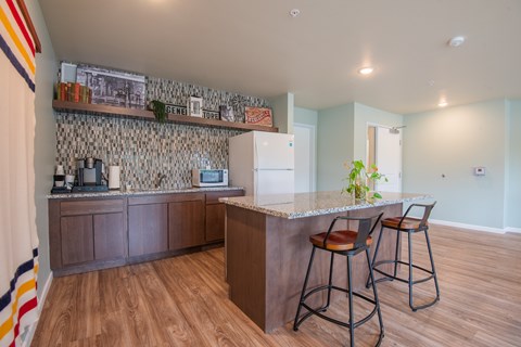 A kitchen with a bar and stools.