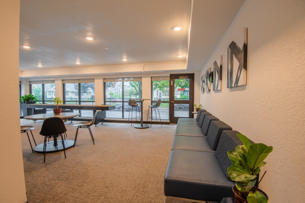 A room with a long couch and a table with chairs.