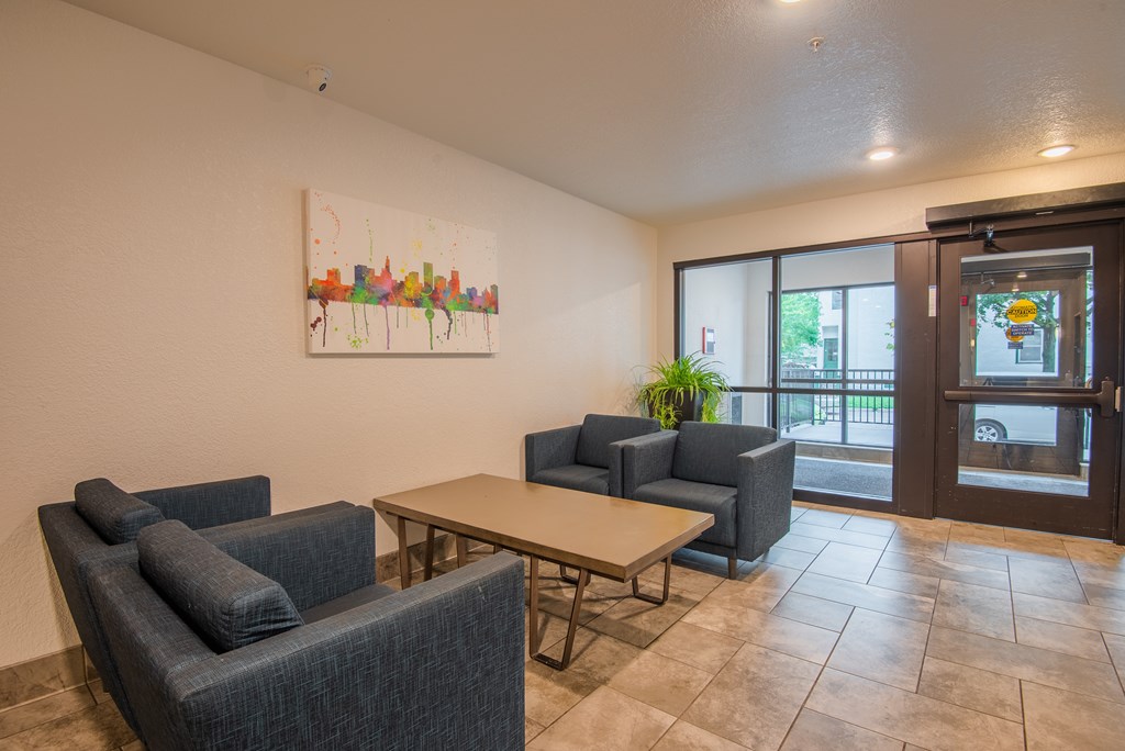 A room with a painting on the wall and a table with chairs.