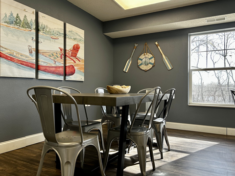 A dining room with a wooden table and chairs.