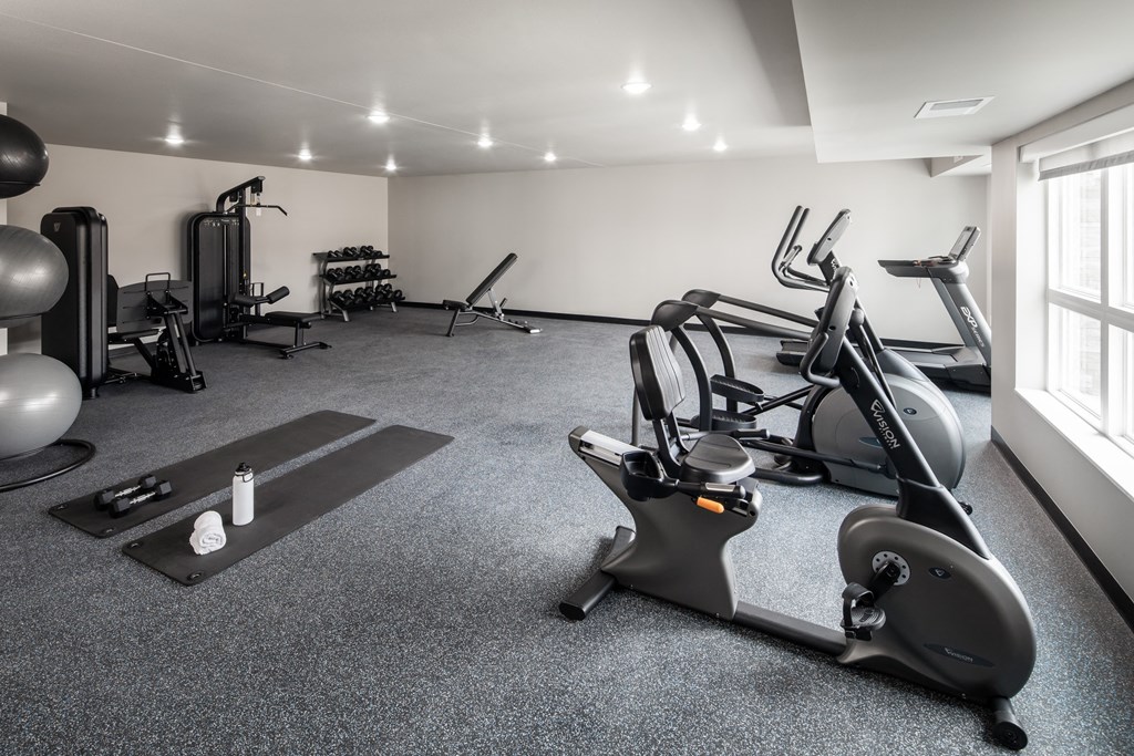 A spacious gym with a variety of equipment including treadmills, elliptical machines, and weights.
