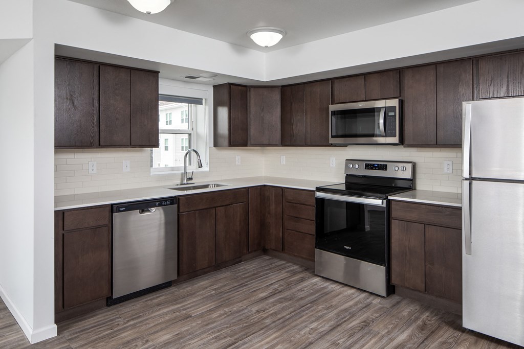 A kitchen with dark brown cabinets and stainless steel appliances.