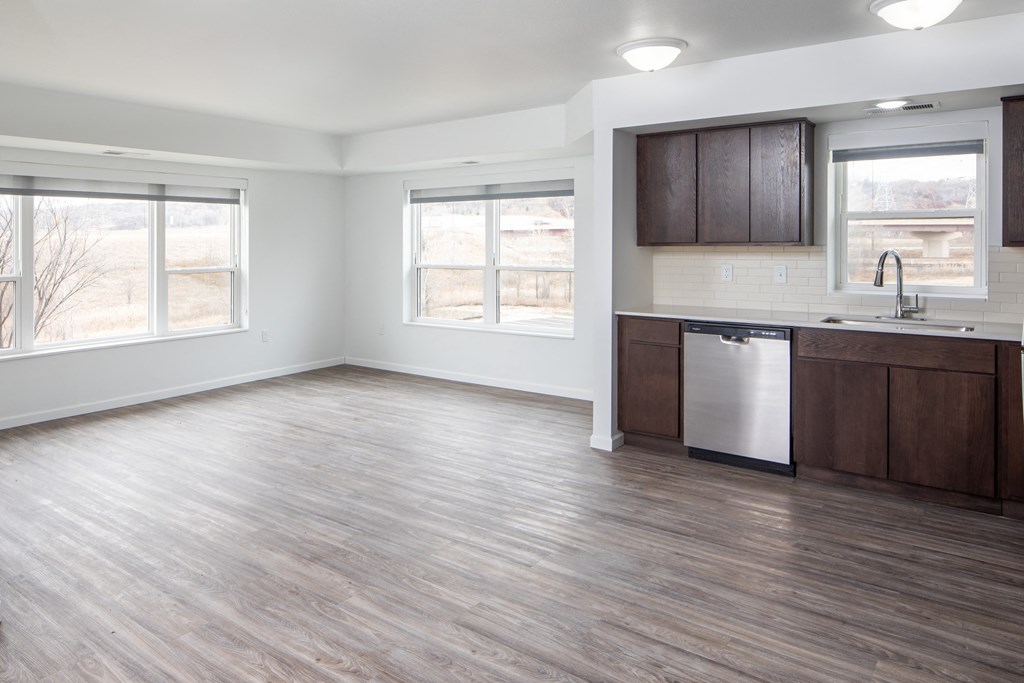 A kitchen with wooden floors and a stainless steel dishwasher.