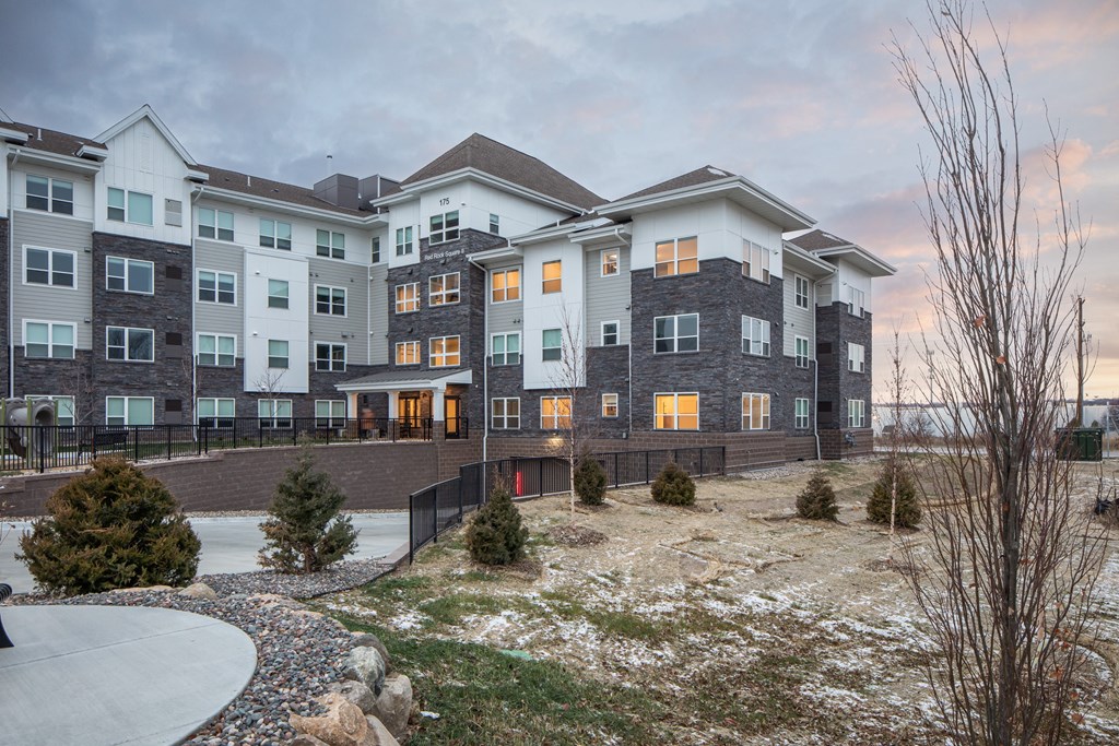 A large, modern apartment complex with a mix of grey and beige exterior walls.