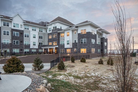 A large, modern apartment complex with a mix of grey and beige exterior walls.