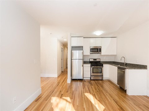 a kitchen with stainless steel appliances and a hard wood floor