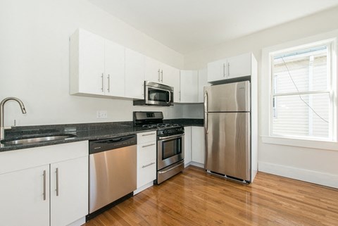 A kitchen with white cabinets and stainless steel appliances.