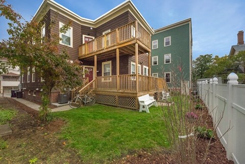 A house with a green wall and a wooden deck.