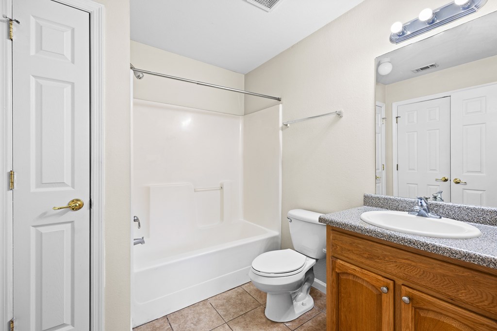 A white bathroom with a toilet, sink, and bathtub.