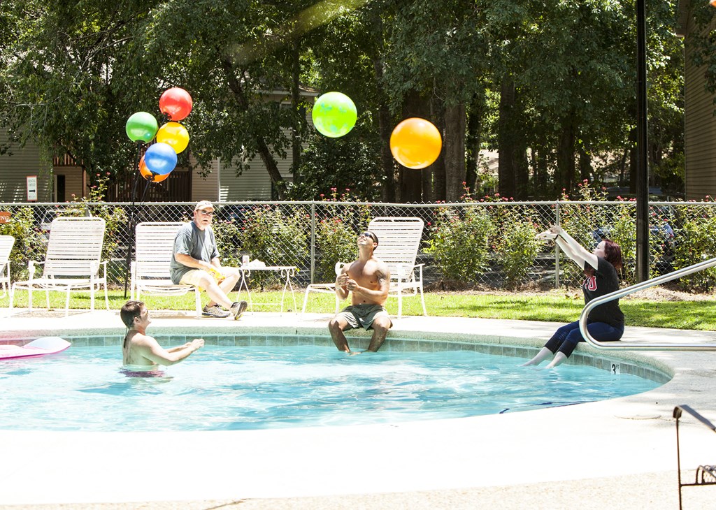 a group of people in a pool playing with balloons