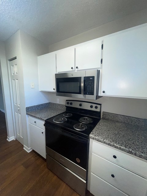 A kitchen with a stove top oven and microwave above it.
