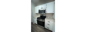 A kitchen with white cabinets and a granite countertop.