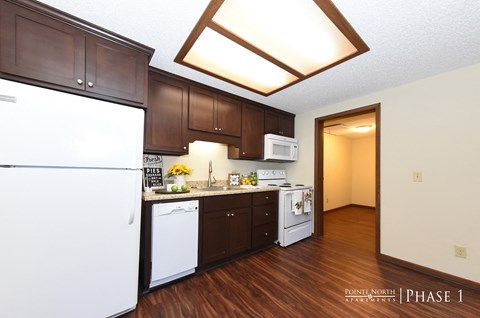 a kitchen with white appliances and dark wood cabinets