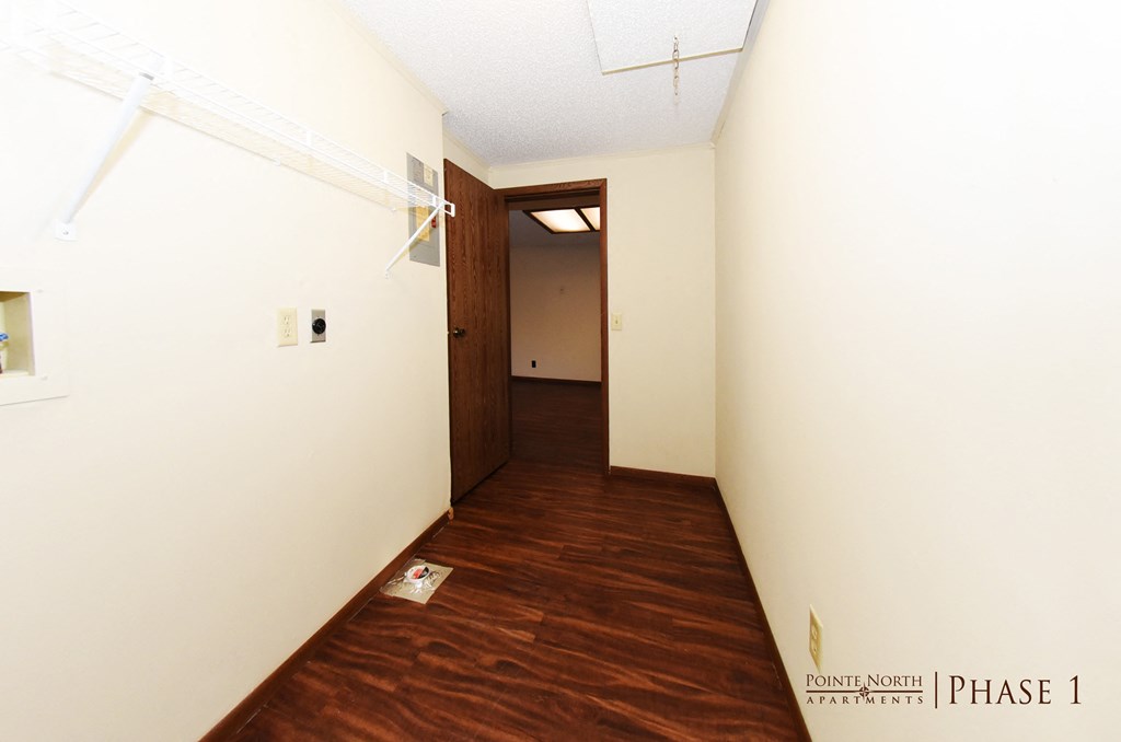 a hall way with a wood floor and white walls