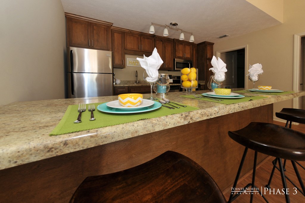 a kitchen with a granite counter top with plates and utensils on it