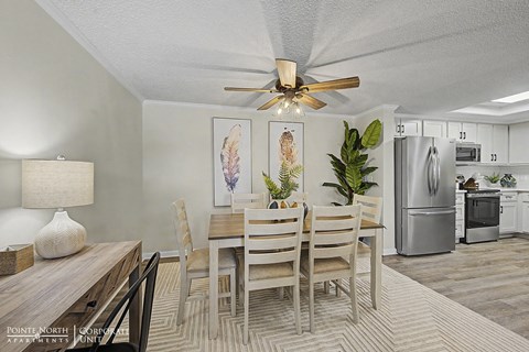 A dining room with a wooden table and chairs.