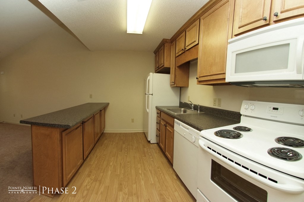 a kitchen with white appliances and wooden cabinets and a white stove and refrigerator