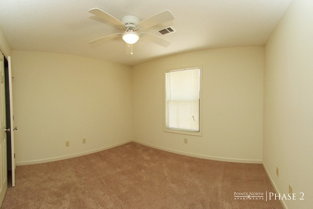 a bedroom with a ceiling fan and a window