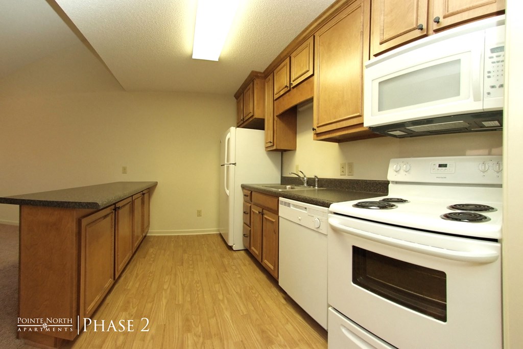 a kitchen with white appliances and wooden cabinets and a white stove