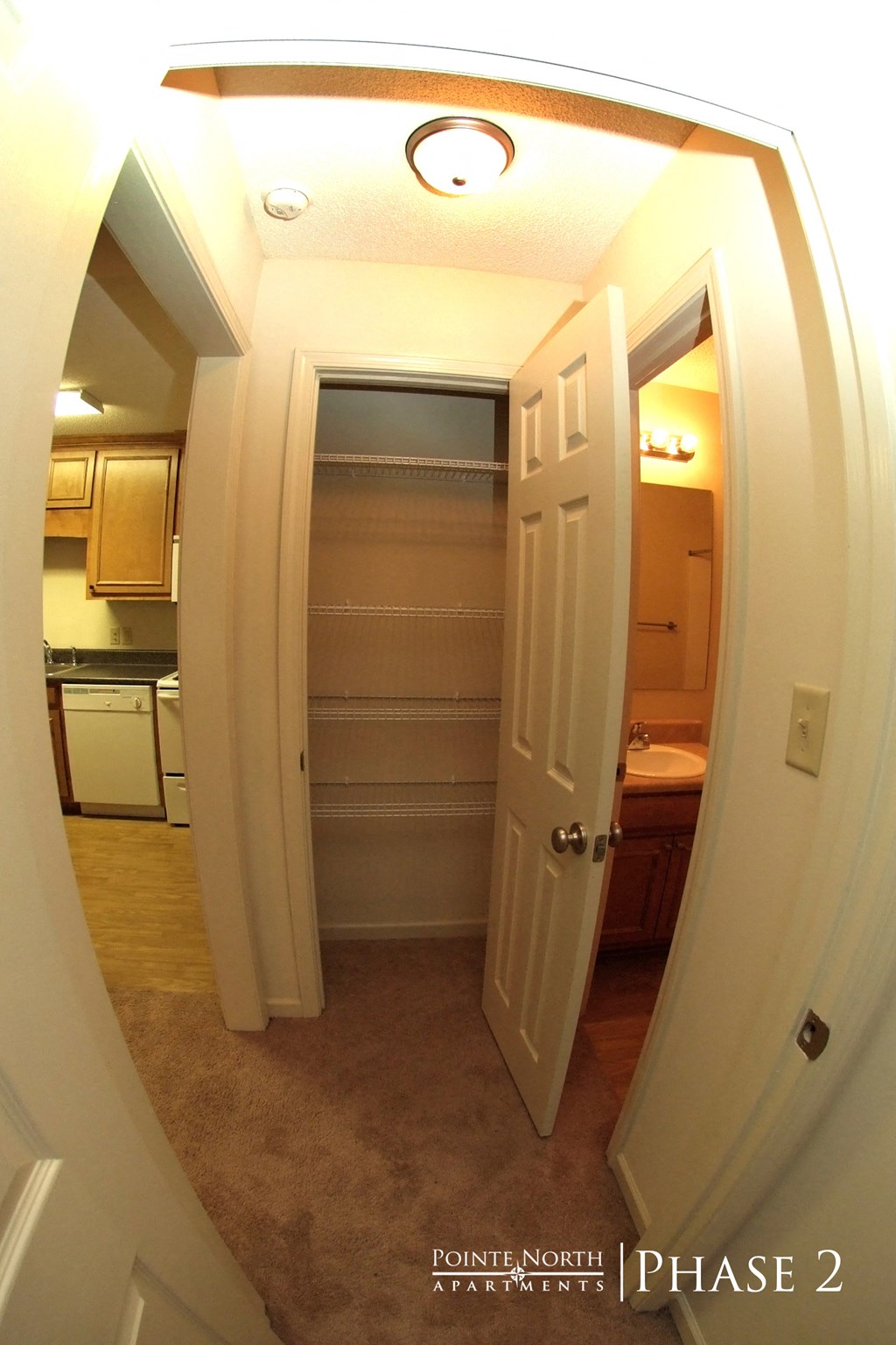 a view through a hallway into a bathroom with a shower and a closet