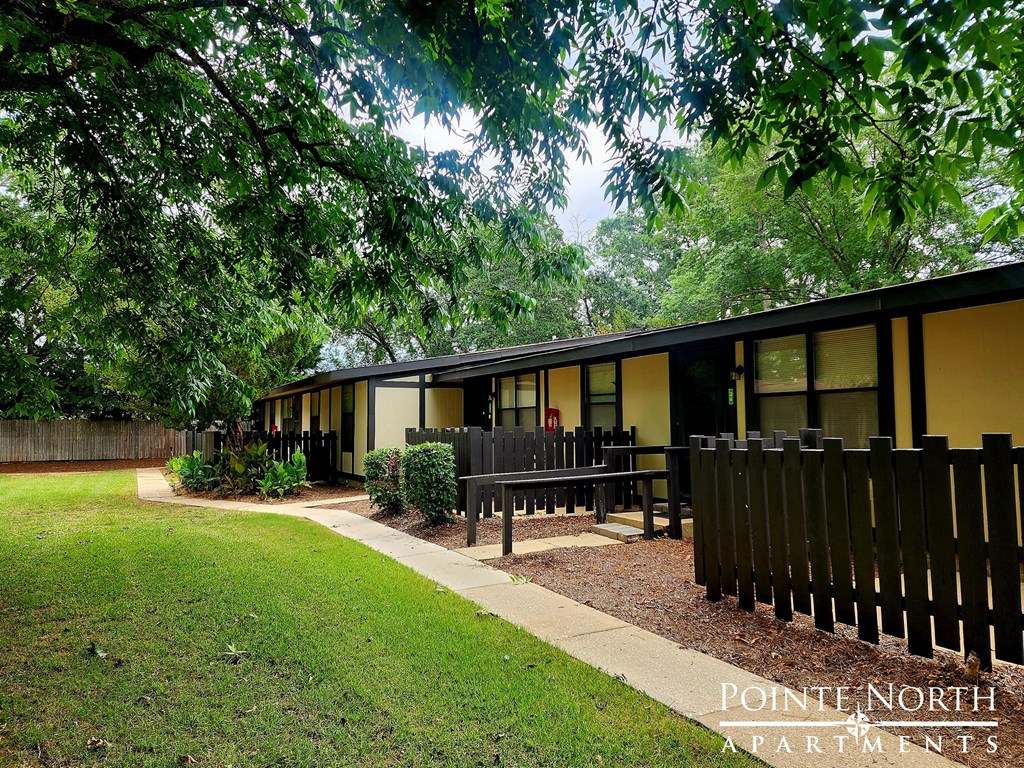 a small house with a yard and a wooden fence