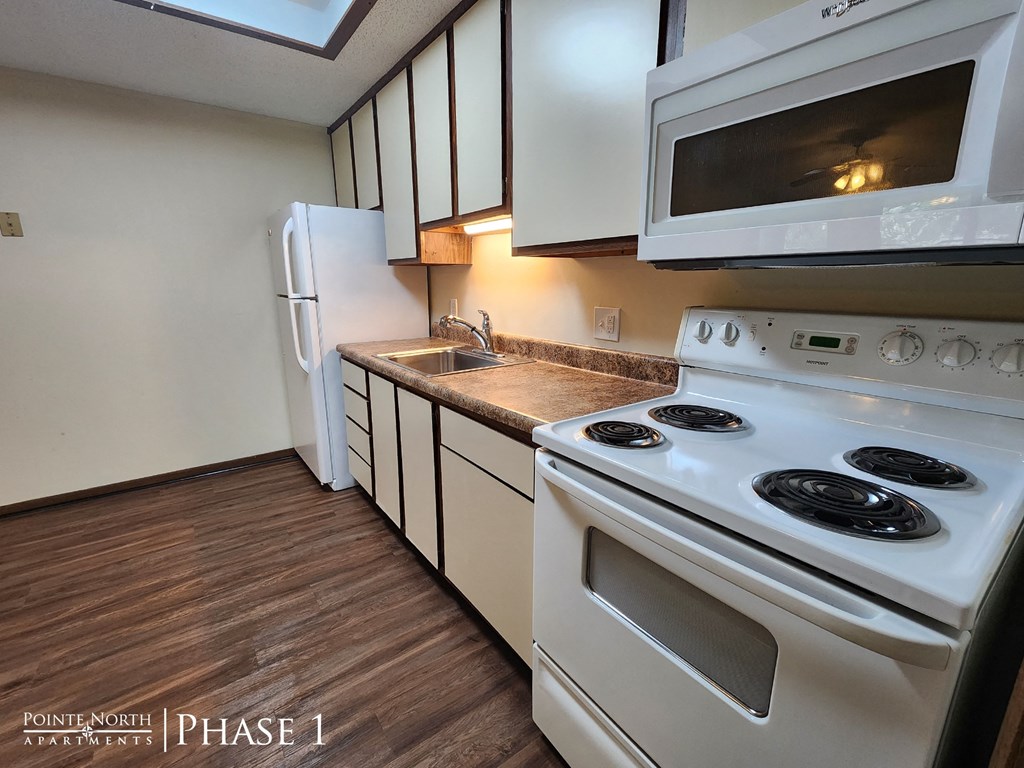 a kitchen with white appliances and white cabinets and a white refrigerator