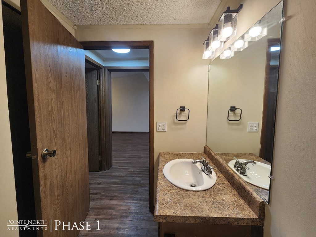 a bathroom with a sink and a mirror and a door