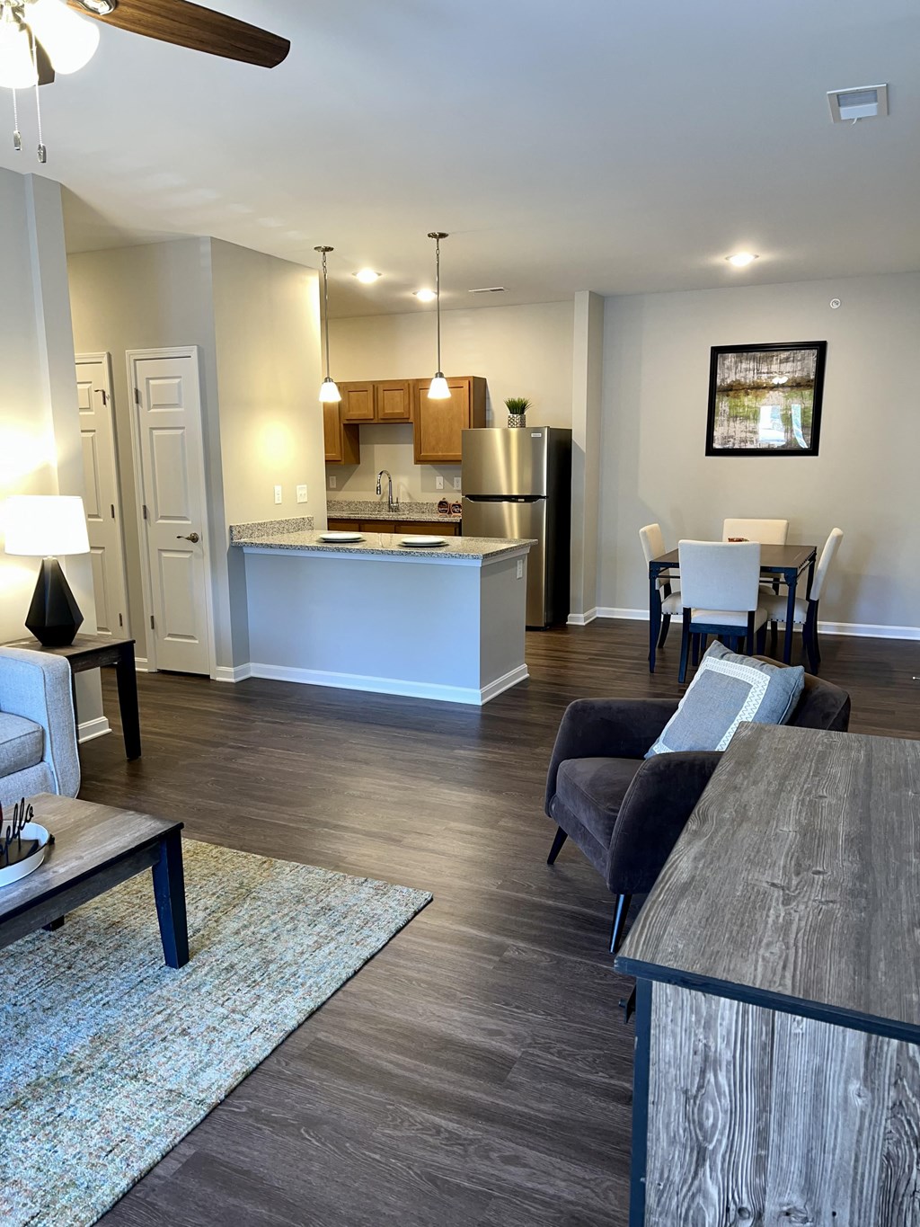 a view of a living room and a kitchen with a table and chairs
