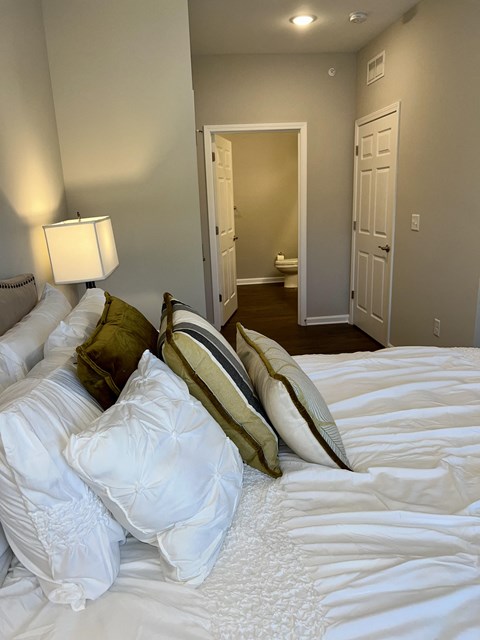 a bedroom with a large bed with white sheets and pillows