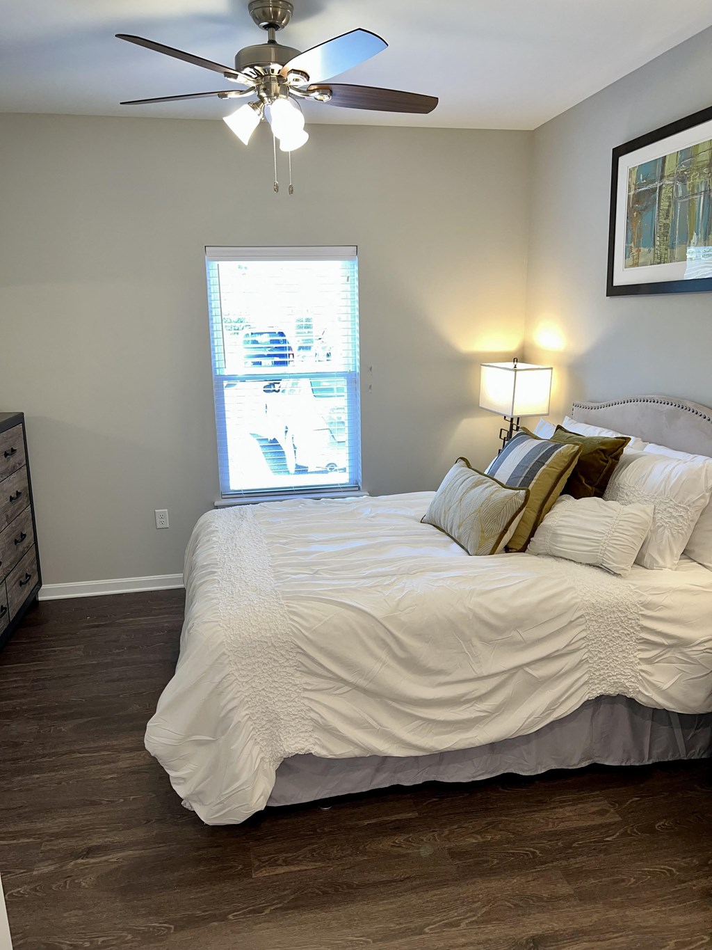 a bedroom with a large bed and a ceiling fan