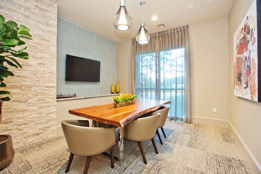 a dining room with a wooden table and chairs and a tv on the wall