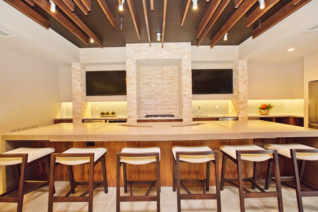 a kitchen with a bar and chairs in front of a fireplace