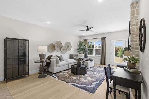 A living room with a white couch, a black chair, and a rug.