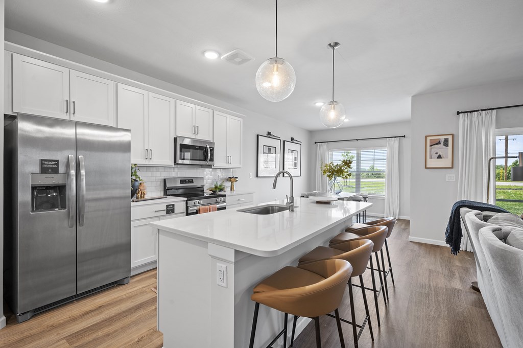 A modern kitchen with a large island and stainless steel appliances.