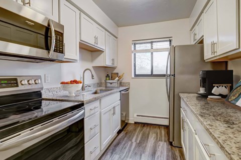 A kitchen with white cabinets and a black stove top oven.