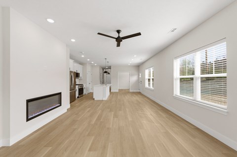 A spacious room with a fireplace and a ceiling fan.