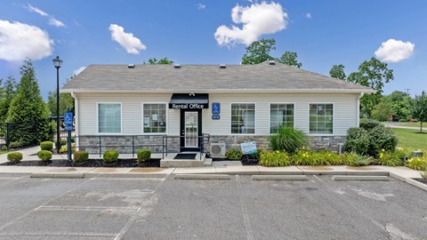 A rental office building with a parking lot in front.