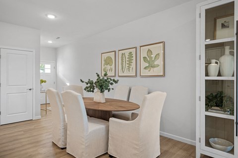 a dining room with white chairs and a wooden table