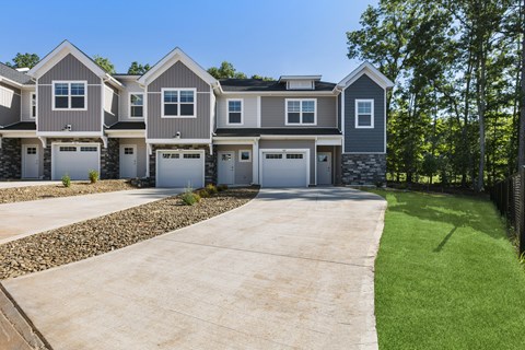 A row of houses with garages and driveways.