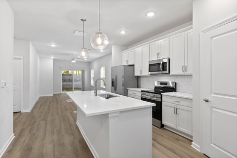 A modern kitchen with white cabinets and a large island.