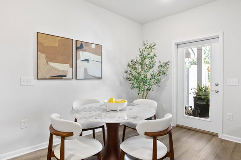 A dining room with a white table and chairs.