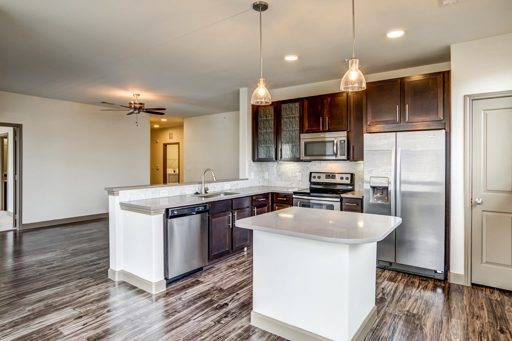 a kitchen with stainless steel appliances and white counter tops