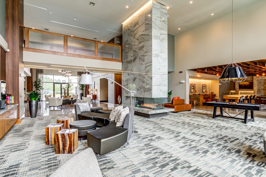 a large lobby with couches and tables and a fireplace