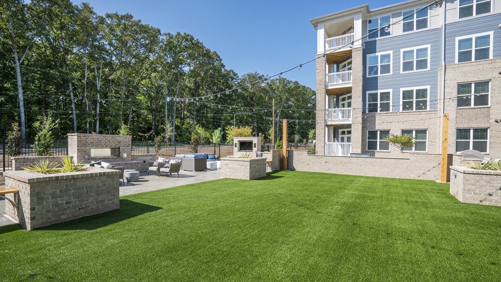 a backyard with a lawn and a fire pit