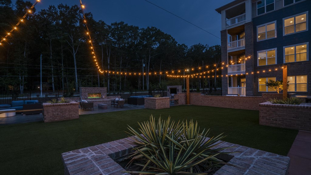 a backyard party area at night with string lights