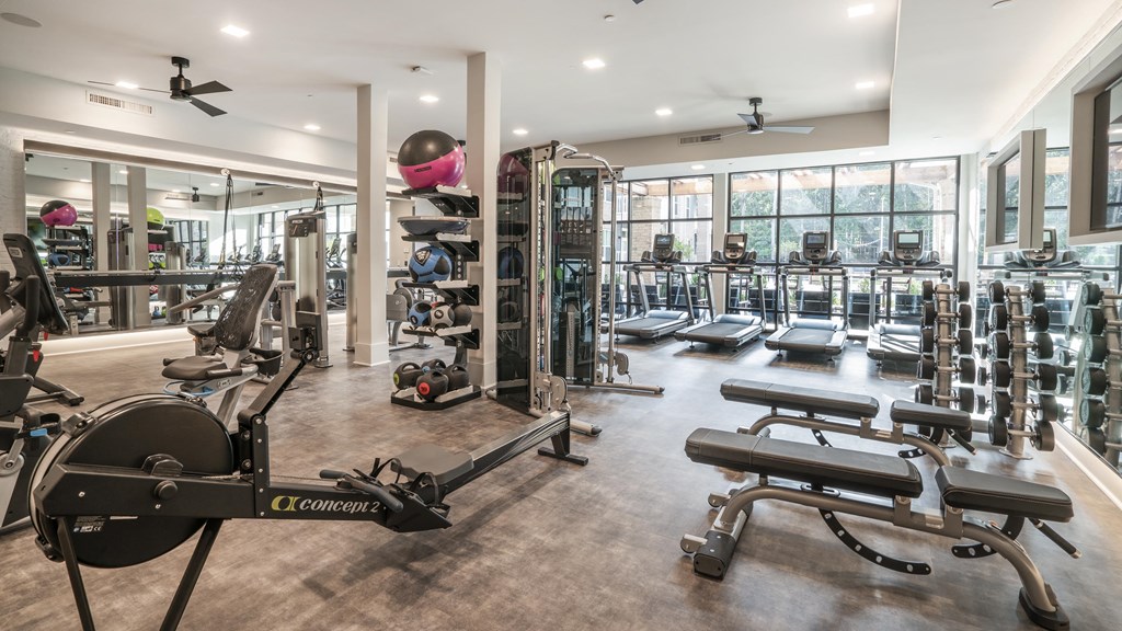 a gym with weights and other exercise equipment and windows