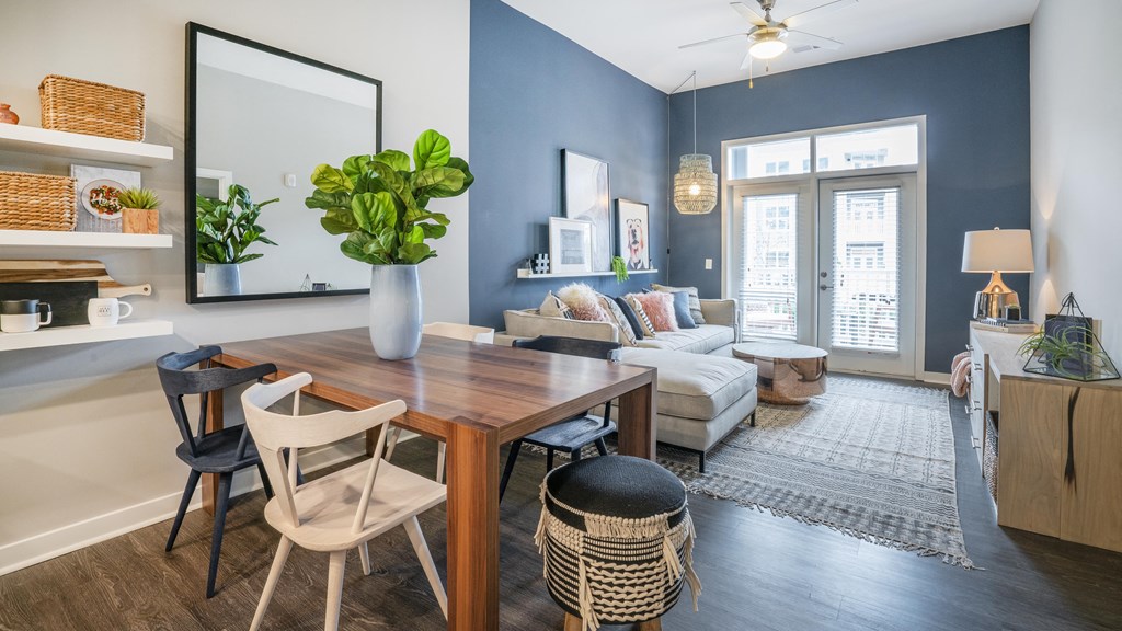 a living room with blue walls and a dining room table